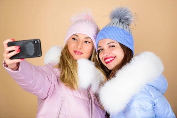 Il nostro migliore inverno. Amici studenti. Ragazze col berretto. shopping stagionale. abbigliamento moda invernale. Piumino. E 'l'ora dei selfie. donne in cappotto caldo imbottito. Vacanze di Natale. buone vacanze invernali — Foto Stock