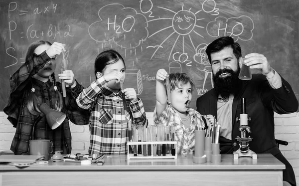 Σχολικός επιστήμονας που σπουδάζει επιστήμη. πίσω στο σχολείο. ευτυχισμένο παιδί δασκάλα. Τα μικρά παιδιά μαθαίνουν χημεία στο σχολικό εργαστήριο. φοιτητές που κάνουν επιστημονικά πειράματα με μικροσκόπιο στο εργαστήριο — Φωτογραφία Αρχείου