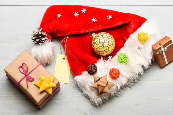 산타 모자와 크리스마스 선물 상자입니다. 산타에서 크리스마스 선물. 산타 모자 흰색 배경 상단보기입니다. 분위기는 모든 세부 사항에 관한 것입니다. 새해와 크리스마스 장식. 겨울 휴가 속성 — 스톡 사진