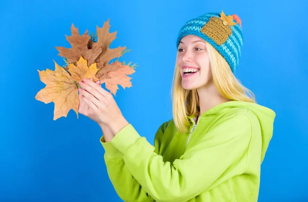 Жінка носить в'язаний капелюх тримає опале листя. Догляд за шкірою на осінь. Насолоджуйтесь осіннім сезоном. Осінні кінчики шкіри. Яскравий момент. Поради щодо догляду за шкірою та краси. Активний відпочинок і відпочинок осінній сезон — стокове фото