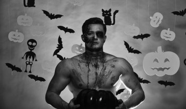 Canavar yüz ve göğüs üzerinde kan olan siyah kabak tutar.