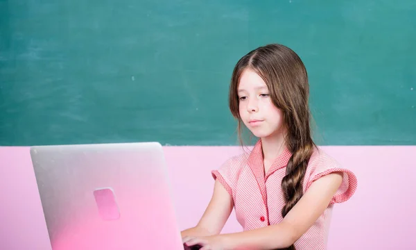Schoolgirl surfing internet. Online course. Do homework or play games. Online school. Online schooling. Distant education. Watching video lessons. Pupil study digital technology. Educative content