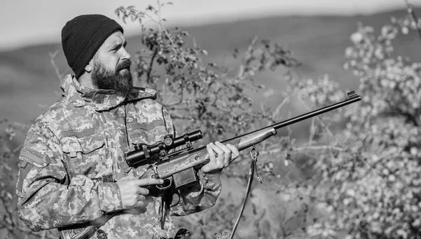Bearded hunter spend leisure hunting. Hunting equipment for professionals. Hunting is brutal masculine hobby. Man aiming target nature background. Hunter hold rifle. Aiming skills. Hunting permit — Stock Photo, Image