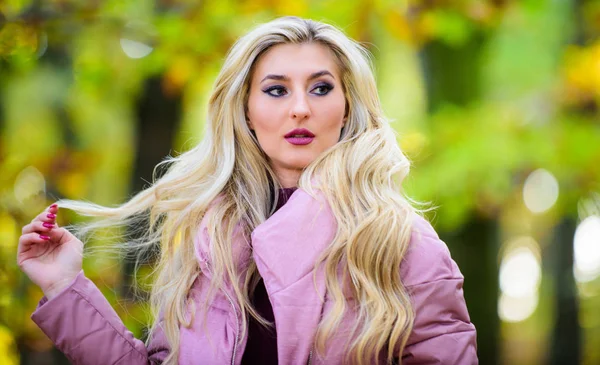 Autumn hair care concept. Autumn hair care is important so as to avoid dry frizzy hair. Cold blonde concept. How to repair bleached hair fast and safely. Girl fashionable blonde walk in autumn park