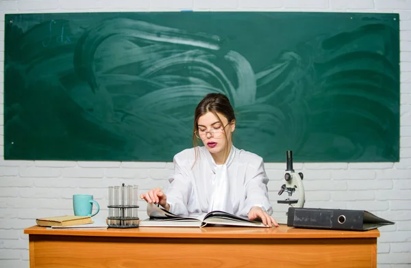 Terug te komen in de onderwijs modus. Mooie leraar lezen aan tafel in school laboratorium. Sexy vrouw terug naar de klas. Terug naar schooltijd. Welkom terug om te studeren. Onderwijs en wetenschap — Stockfoto