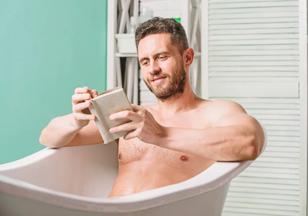 Détends-toi à la maison. Détente totale. L'hygiène personnelle. Système nerveux bénéfice baignade. Relax concept. Homme torse musculaire détendre baignoire et lire le livre. gars détendu lecture livre tout en se relaxant dans un bain chaud — Photo