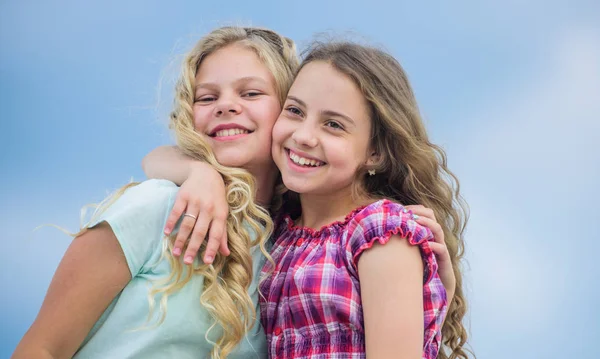 Curly e penteados lindos. Lindas irmãs. Serviços de salão de cabeleireiro. Duas meninas crianças com cabelos longos encaracolados. Meninas com cabelo encaracolado natural saudável. Procedimento de beleza. Crianças adoráveis — Fotografia de Stock