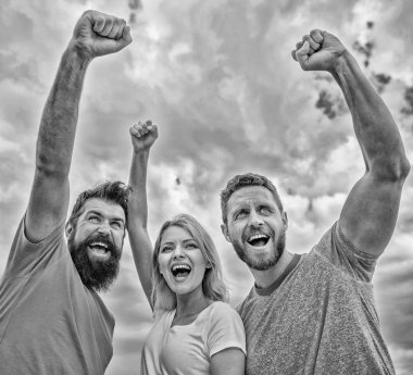 Kadın ve erkek kendine güvenen başarılı gökyüzü arka plan bak. Tutarlı ekip davranışlarını. Başarı kutlamak. Evet yapabiliriz. Ohesive takım oluşturmak için yollar. Üçlü stand güvenle yükseltilmiş yumrukları ile mutlu