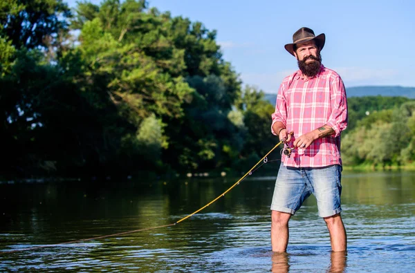 Fly fish hobby. Summer fishery activity. fisherman in lake water. hipster fishing with spoon-bait. big game fishing. relax on nature. mature bearded man with fish on rod. He is ready for the fishing — Stock Photo, Image