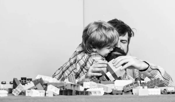 Padre e hijo crean construcciones. Barbudo e hijo juegan juntos. Formas seguras de vincularse con su hijo. Padre hijo juego. Papá y el niño construyen bloques de plástico. Desarrollo del cuidado infantil. Tiempo libre familiar —  Fotos de Stock