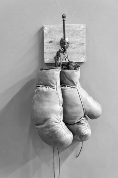 retro boxing gloves. vintage sport equipment. boxing concept. old boxing gloves on hanger. history of sport. worn gloves. stamina. boxing fight club. Sport success. Vintage gloves hang on hook