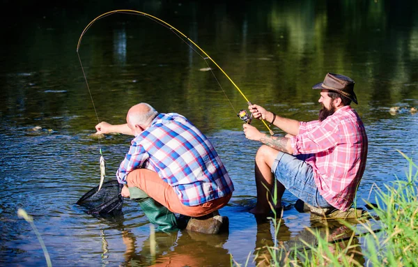 男人的飞鱼爱好。退休渔业。退休的父亲和成熟的胡子的儿子。两个男性朋友一起钓鱼。愉快的渔民友谊。大游戏钓鱼。放松自然。准备钓鱼 — 图库照片