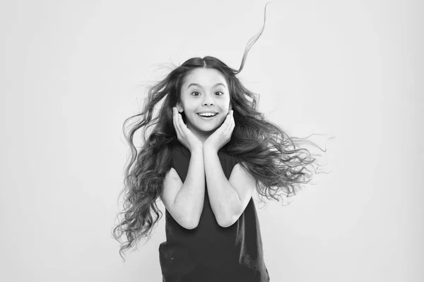 Cosas que haces para dañarte el cabello. Niña adorable niño largo ondulado pelo amarillo de fondo. El viento también puede dañar el cabello. Fuertes vientos persistentes pueden crear enredos y enredos en el cabello ondulado y rizado largo — Foto de Stock