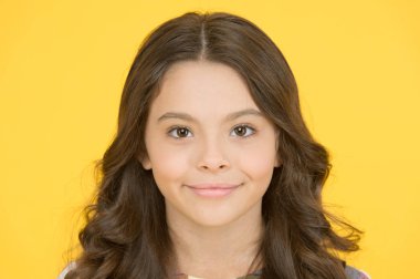 Eğri yumuşak kıvırma maşa. Gevşek ama cilalı görünümlü bukleler. Küçük gülümseyen çocuk kıvırcık saç modeli. Moda trendi. Sıkıca tanımlanmış halkalardan gevşek sahil dalgalarına kadar. Kıvırcık ve mutlu. Mükemmel kıvırcık saç modeli