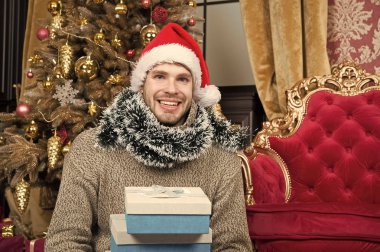 Noel eğlenceli. Adam evde Noel kutluyor. Noel Baba şapkası erkekte xmas hediye tutun. Xmas hediye kutuları ile mutlu bir adam. Teslimat Noel hediyeleri. Noel kutlamaları