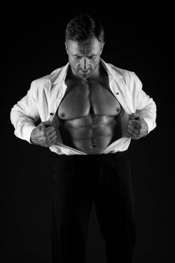 Kişisel tarzı bir adam da çekicidir. Siyah arka planda seksi adam. Yakışıklı adam beyaz gömlek altında uygun gövde ile kas altı paketi abs. Atletik adam gösteren