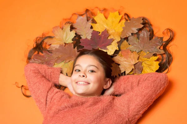 Little girl small child gorgeous long hair and fallen maple leaves. Moisturizing mask. Deep conditioning treatment to combat static and tangles that come with fall. Haircare tips add to fall routine