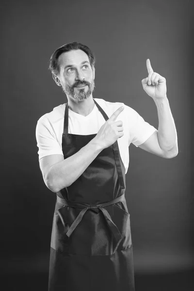 A inventar um novo prato. Cozinhe com barba e bigode use avental fundo vermelho. Homem cozinheiro maduro posando avental de cozinha. Chefe cozinheiro e culinária profissional. Cozinhe comida em casa. Bela receita. Ideias e dicas — Fotografia de Stock