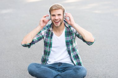 gerçek mutluluk. serbest zaman. online eğitim. müzik dinleyin. ebook kavramı. adam damalı gömlek. öğrenci rahatlayın kulaklık kullanın. mutlu adam açık. adam yere otur. kulaklıkta kaygısız öğrenci