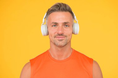 Kablosuz modern. Temiz ses. Modern teknoloji. Olgun adam, müzik dinle kablosuz cihaz sarı arka plan. Hippi modern kablosuz kulaklık kullanmaktan mutlu. Özgürlük kablosuz çalışıyor. Ses Defteri