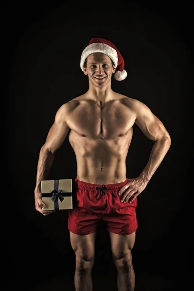 New year party. Santa claus man. Present for Xmas. Happy winter holidays. Red. Christmas shopping. Sexy muscular man in santa hat. Energy inside him. Christmas party time