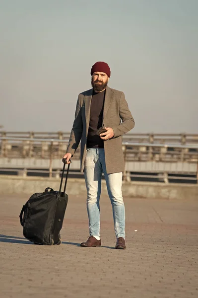 Carry travel bag. Business trip. Man bearded hipster travel with big luggage bag on wheels. Let travel begin. Traveler with suitcase arrive to airport railway station. Hipster ready enjoy travel