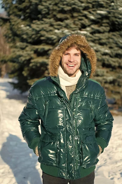 Winter outfit. Man unshaven wear warm jacket with fur snowy nature background. Guy wear winter jacket with furry hood. Hipster winter fashion. Prepared for weather changes. Winter stylish menswear