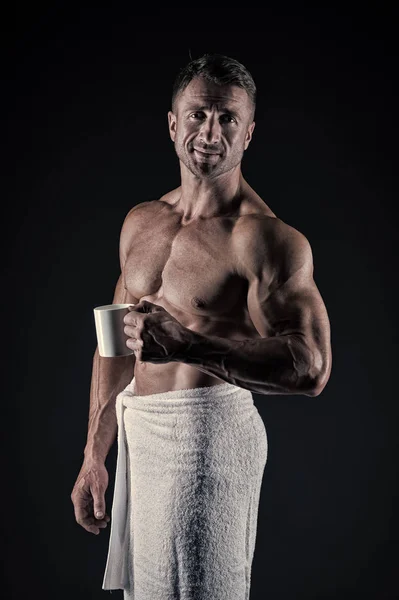 The taste of energy. Athletic man keeping energy diet. Sexy athlete holding cup with energy drink. Healthy diet and sport give him vital energy, vintage filter