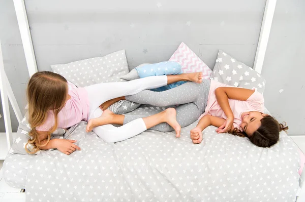 Having fun together. fun before sleep. best friends. sisters playing in bed. sweet dreams. pajama party in bedroom. childhood happiness. kids friendship. happy small girls. good morning — Stock Photo, Image