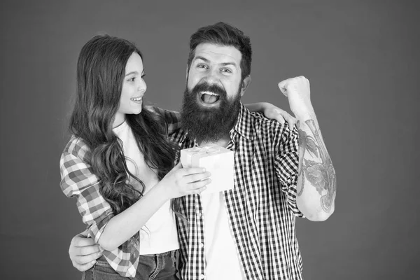 Um presente para o pai dela. Homem barbudo pai e linda menina filha no fundo vermelho. Celebre o dia de pais. Conceito de valores familiares. Relações amigáveis. Padre hipster e a sua filha. Presente surpresa — Fotografia de Stock