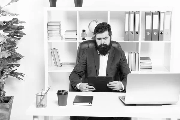 Check list. Man bearded hipster boss sit in leather armchair office interior. Boss at workplace. Manager formal clothing corporate style working. Business people concept. Busy boss in office — Stock Photo, Image