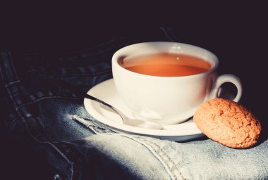 Sağlıklı alışkanlıklar. Çay saati konsepti. Bardak bardak sıcak su ve bir poşet çay. Kupa, kot pantolonla kaynayan su ve çay poşeti dolu. Bitki yeşili ya da siyah yaprak. Seramik bardakta demlenen çay.