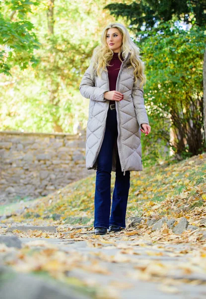 Jacket everyone should have. Puffer fashion trend concept. Girl fashionable blonde walk in autumn park. Oversized jacket trend. Puffer jacket casual and comfortable style. Woman wear warm grey jacket