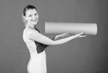 Yoga sınıfı konsepti. Her gün yoga yapıyorum. Kız gülümseyen ince uygun atlet tutun fitness mat. Fitness ve esneme. Kasları germe. Yoga ritmine giriyorum. Hobi ve spor olarak Yoga