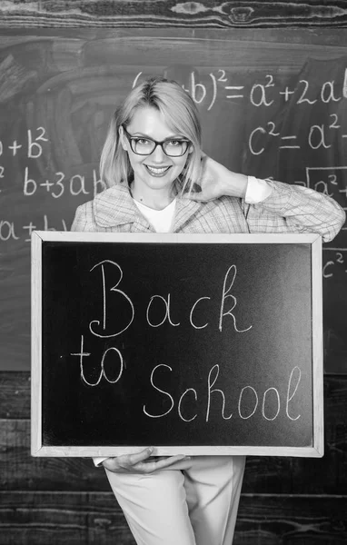 Teacher woman hold blackboard inscription back to school. It is school time again. School teacher glad to welcome pupils. Great beginning of school year. Top ways to welcome students back to school