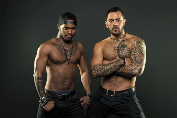 Tattoo is cool. Brutal macho style. Muscular men with fashionable tattoo style. Sexy men with muscular torso. We feel sexy