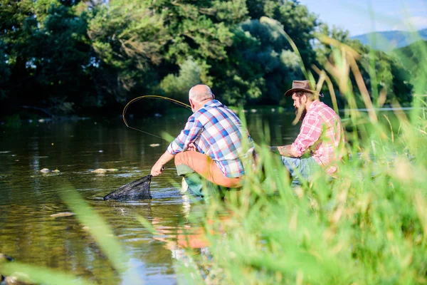 Poaching crime and fishing license. Black market caviar. Poachers fishing. Illegal hunting caviar. Extracts eggs from sturgeon caught river. Trap for fish. Men sit at riverside with fishing equipment — Stock Photo, Image