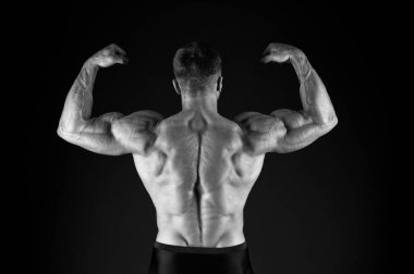 Yılın sporcusu. Siyah arka plan üzerinde sporcu geri görünümü. Güçlü sporcu kol kasları triceps pazı esneme. Sporcu veya vücut geliştirmeci kas geri gösteren