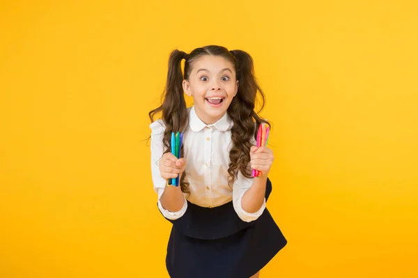 Kunst maken op de eerste schooldag. Gelukkig school kind het houden van markers op gele achtergrond. Klein meisje geniet van tekenlessen op school. School voor creatief denken — Stockfoto