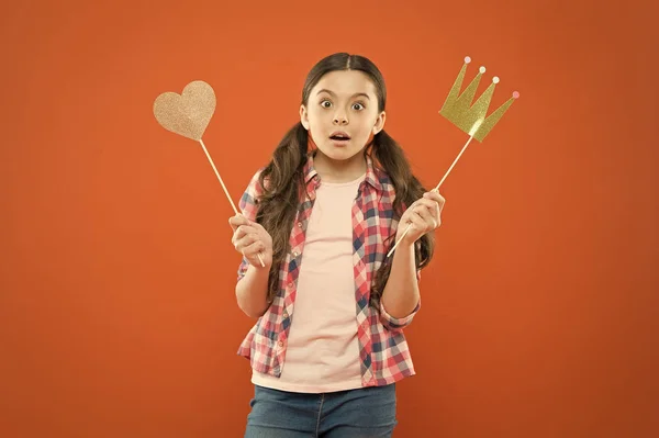 With no expectation of reward. Little girl holding prop crown and heart on stick as favorite reward. Cute mini miss beauty pageant winner enjoying reward for success. Awarding with prize and reward — Stock Photo, Image