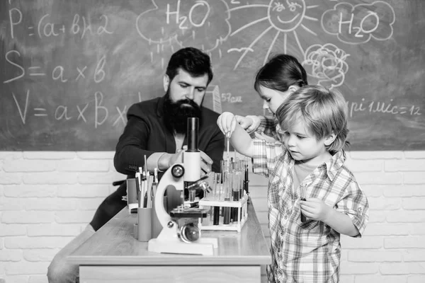面白い学校の授業。学校教育学校化学実験スクールクラブ子供に化学を説明する魅惑的な化学反応教室でテストチューブを持つ教師と生徒 — ストック写真