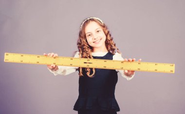Matematik dersi. Eğitim ve bilgi. BTMM okul disiplini. Büyük cetveli olan öğrenci kız. Küçük kız okula geri döndü. Okul öğrencisi geometri öğreniyor. Matematik grafik araçları kavramı