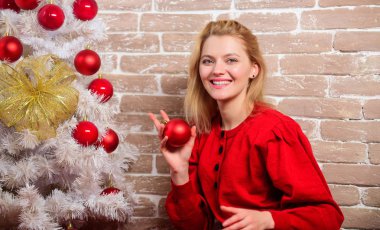 Tatil kutlamaları başlamadan önce yapmanız gerekenler. Noel arifesi konsepti. Elbiseli kız süseşyaları ile Noel ağacı süsleyin. Noel'i bekliyorum. Noel ağacı yakınında rahatlatıcı kadın neşeli