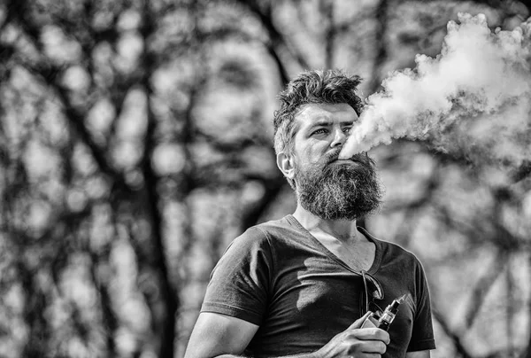 Концепция снятия стресса. Бородатый человек курит вапе. Курение электронных сигарет. Мужчина с длинной бородой, расслабленный от курения. Человек с бородой и усами дышит дымом. Белые облака ароматного дыма — стоковое фото