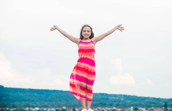 Free and carefree. Good vibes. Happy international childrens day. Happy childhood. Cute little girl in summer dress outdoors sky background. Happy vacation. Enjoying relax. Child happy small girl — Stock Photo, Image