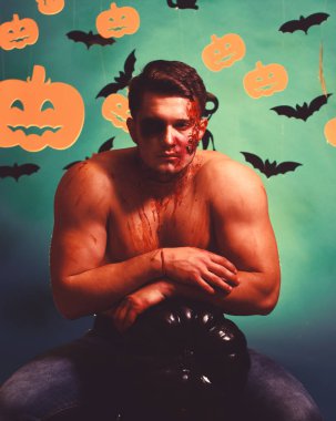 Canavar yüz ve göğüs üzerinde kan olan kabak üzerinde eğilir.