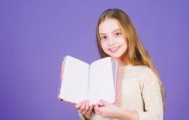 Kitap konsepti. Çocukluk edebiyatı. Gelişim ve eğitim. Okuma becerisi. Kişisel günlük. Not defteri planlayıcısı. Okul kırtasiye. Daha fazla bilgi edinin. Kız kitap mor arka plan tutun. Çocuk gösteri kitabı not defteri