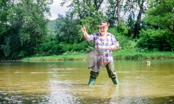 La jubilación es un trabajo a tiempo completo. actividad deportiva y hobby. Cebo para truchas. Pothunter. hombre pescando peces. pescador retirado. pesca de caza mayor. hombre maduro pescando. fin de semana de verano. pescador con caña de pescar — Foto de Stock