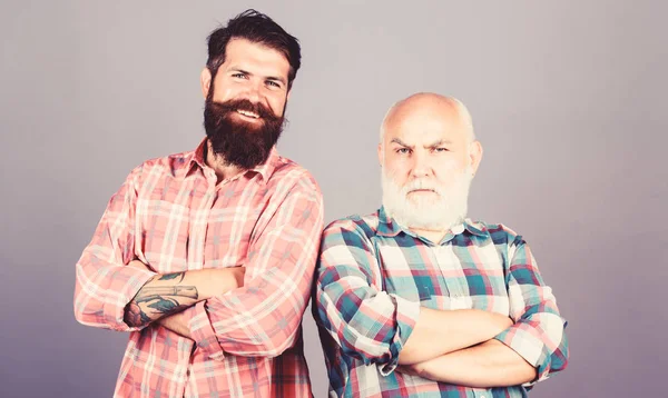 Brutal guys with long beard. Bearded friends. Hairdresser salon. Father and son. Men bearded hipster stand back to back. Family team. Barbershop concept. Barber well groomed handsome bearded man