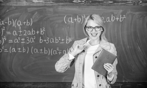 Teaching complex multifaceted activity. Teacher smart woman with book explain topic near chalkboard. What makes great teacher. School teacher explain things well and make subject interesting — Stock Photo, Image